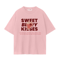 A light pink TOTZ WORLD  premuim cotton short-sleeve t-shirt with a graphic on the front reading 'SWEET BERRY KISSES' in dark red, featuring a strawberry illustration and a small tag at the inner collar that reads 'TOTZ  WORLD'.