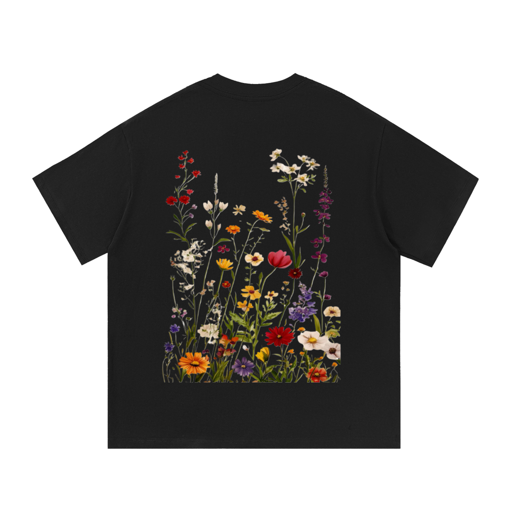 A black short-sleeve t-shirt with a large, colorful graphic print of wildflowers on the back, displayed against a solid white background.